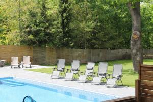 a group of chairs sitting next to a swimming pool at Salis Resort in Wieliczka