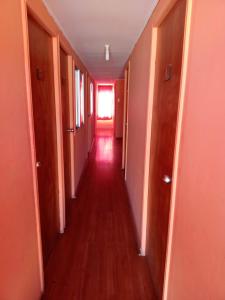 an empty hallway with a long hall with a window at Hostal Manuel Bugueño in El Cerrillo