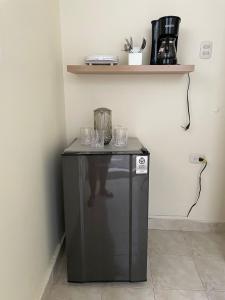 a small black refrigerator with glasses on top of it at Casa Estela in Cartagena de Indias +4 photos
