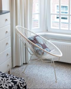 a white chair in a room with windows at Authentic Amsterdam Apartment RAI in Amsterdam