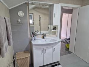 een badkamer met een witte wastafel en een spiegel bij Apartman IN in Bihać +40 foto's