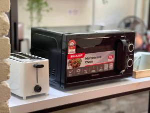 a microwave oven sitting on a counter next to a toaster at Pine Muntri in George Town