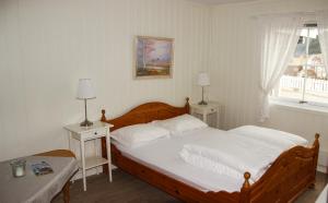 a bedroom with a large bed and two night stands at Sandli Overnatting in Alvdal