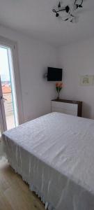 a bedroom with a white bed and a television at Terrazza mare e monti in Alba Adriatica