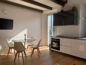 切尔诺比奥Spazio Perlasca Apt 3 - Cernobbio Como Lake的配有桌椅的厨房和餐厅