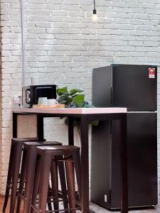 Una mesa con dos taburetes y un refrigerador. en Pine Muntri, en George Town