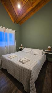 a bedroom with a bed with two towels on it at Posada Alma del Cerro in El Calafate