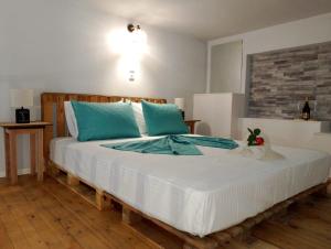 a bedroom with a large bed with blue pillows at Old Cafe Apartment in Skala Kallirachis