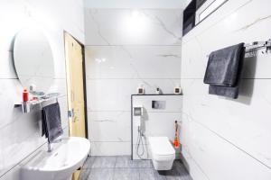 a white bathroom with a sink and a toilet at Riverside Retreat in Kalyānpur +43 photos
