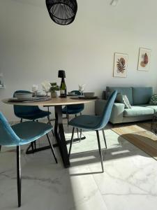 a living room with a table and chairs and a couch at Penthouse met exclusief dakterras Casa Buena Vida Orihuela Costa in Orihuela Costa