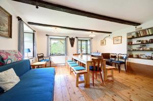 a living room with a blue couch and a table at Chalupa Ořešák - Walnut House in Svojšice +26 photos