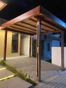 a wooden pergola on a patio at night at Casa em condomínio Campina Grande in Campina Grande