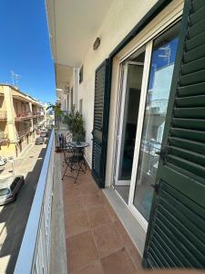a balcony of a building with green doors and a table at Terrazza Adriatica in Polignano a Mare +2 photos