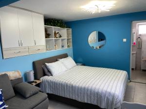 ein blaues Schlafzimmer mit einem Bett und einer Couch in der Unterkunft Sutomore Panorama Studio in Sutomore + 12 Fotos