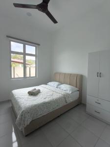 a bedroom with a bed with a ceiling fan at Villa Nurami in Melaka +8 photos