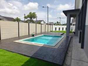 a swimming pool in the backyard of a house at Villa Nurami in Malacca