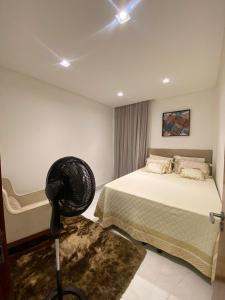 a bedroom with a bed and a fan in it at Casa em condomínio Campina Grande in Campina Grande