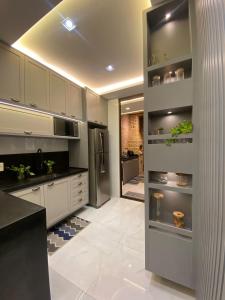 a kitchen with white cabinets and stainless steel appliances at Casa em condomínio Campina Grande in Campina Grande +20 photos