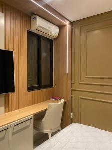 a bedroom with a desk and a television and a bed at Casa em condomínio Campina Grande in Campina Grande