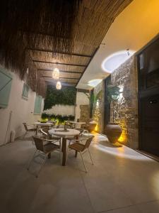 a restaurant with tables and chairs and a stone wall at Luvenza Hotel Alaçatı in Çeşme
