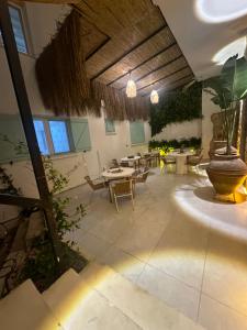 a patio with a table and chairs and a large vase at Luvenza Hotel Alaçatı in Çeşme