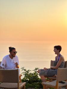 two men sitting in chairs on the beach at SECRET HILL in Athani