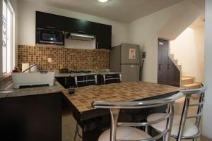 a kitchen with a counter and bar stools in it at Casa Dorada in León