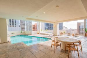 an indoor pool in a building with a table and chairs at Spacious 2BR HighRise, Gym, Pool, Parking, W-D, Golf in Phoenix