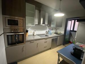 a kitchen with stainless steel appliances and a table at Apartamento Aguadulce in Aguadulce