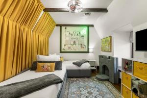 a bedroom with two beds and a tv and a couch at Tulsa Gathering Place Castle-a Good Knight's Rest in Tulsa