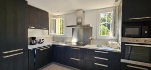 a kitchen with dark wood cabinets and a microwave at T3 Dolce & Vita A3 avec Piscine et vue Montagnes in Propriano