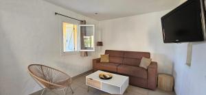 a living room with a couch and a tv at T3 Dolce & Vita A3 avec Piscine et vue Montagnes in Propriano