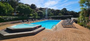 a swimming pool with lounge chairs and a fountain at T3 Dolce & Vita A3 avec Piscine et vue Montagnes in Propriano +35 photos