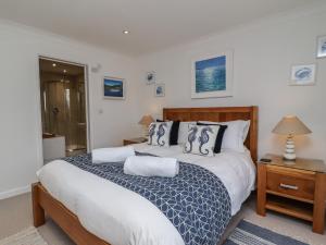 a bedroom with a large white bed and a night stand at Sea Breeze in Carbis Bay