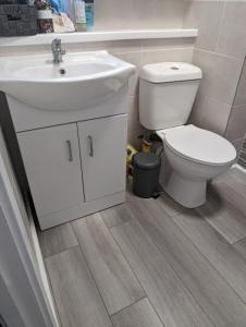 ein Badezimmer mit einem weißen Waschbecken und einer Toilette in der Unterkunft Family house near the beach! in Saint Columb Minor