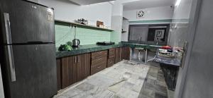 eine große Küche mit Holzschränken und grünen Wänden in der Unterkunft Infinity Homestays 2 in Udaipur + 2 Fotos