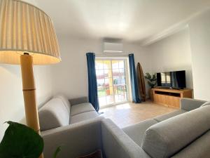 a living room with a couch and a television at Porto de Mós Family House in Lagos