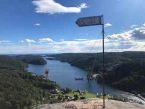 a sign on the side of a mountain overlooking a river at Barnevennlig med strand og hage - Wifi in Søgne