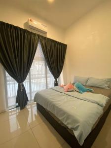 a bedroom with a bed with two stuffed animals on it at WeStay Homestay 15-1 in Bukit Mertajam