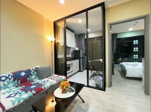 a living room with a couch and a large mirror at The Base Prime in Pattaya Central