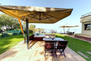 eine Terrasse mit einem Tisch und Stühlen unter einem großen Sonnenschirm in der Unterkunft Royal Mediterran in Siófok