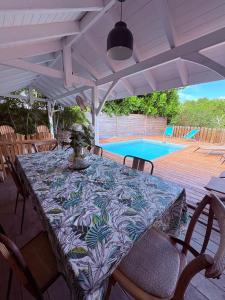 een tafel en stoelen op een patio met een zwembad bij Villa Soualiga Orient Bay 150 m de la plage in Orient Bay