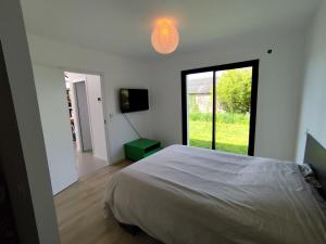 une chambre avec un lit et une grande fenêtre dans l'établissement Le Pélican By Nid'Ouest, à Plovan