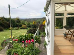 a porch of a house with a garden with flowers at Ryedale House in Sleights