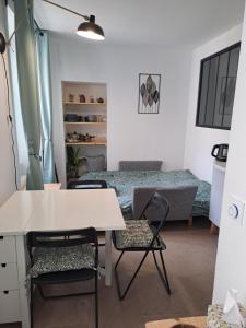 a room with a desk and chairs and a bed at Studio du BoisDHyver in Fontainebleau