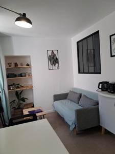a living room with a couch and a table at Studio du BoisDHyver in Fontainebleau +7 photos