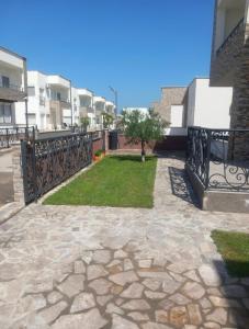 a stone walkway with a fence and a yard at Dara Apartmani in Donji Štoj