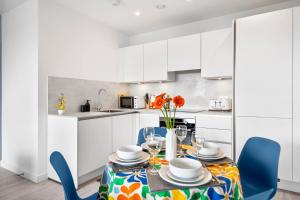 海斯Stylish 1BR Flat in Hayes 4 Guests-5 Min to Heathrow#20 Min to Central London的配有桌椅的厨房和餐厅