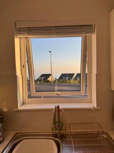 a kitchen sink with a window with a view of a street at Modern, Tiny Home, Beach Retreat in Southerndown +18 photos
