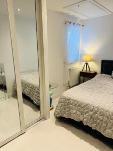 a bedroom with a mirror next to a bed at Modern, Tiny Home, Beach Retreat in Southerndown